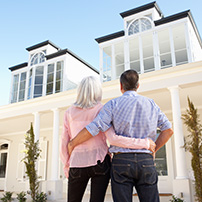 A Couple Embracing Outside a House with Seamless Gutters Service 