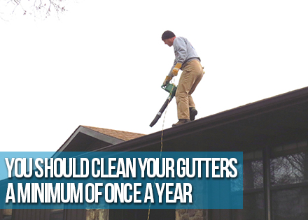 Man Cleaning Rain Gutters whit a Blower