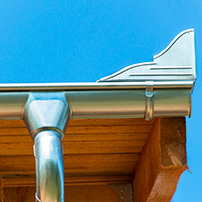 Aluminum Rain Gutter Attached to the Facia Board and a Clear Blue Sky