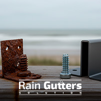 A close-up photograph comparing a rusted, pitted steel fastener from a cheap gutter installation next to a pristine stainless steel screw and anodized aluminum bracket after years of coastal exposure.