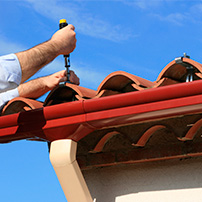 Man installing a rain gutter in a house 