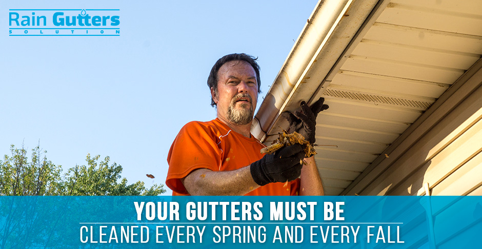 Man cleaning up installed rain gutters in fall 