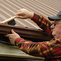 Senior man making a rain gutter cleaning 